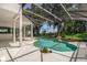 Inviting screened-in pool area with a uniquely shaped pool, rock feature, and lush landscaping at 16951 Florence View Dr, Montverde, FL 34756