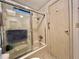 Bathroom showing shower/tub combo with glass doors and decorative patterned wall at 175 Hibiscus Way, Leesburg, FL 34748