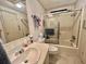 Bathroom features a shower over the bath, vanity, and patterned wallpaper at 175 Hibiscus Way, Leesburg, FL 34748