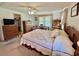 Bedroom with neutral carpet, ceiling fan, and wooden furnishings at 175 Hibiscus Way, Leesburg, FL 34748
