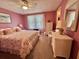 Cozy bedroom featuring floral bedding, wicker furniture, and soft natural light for relaxation at 175 Hibiscus Way, Leesburg, FL 34748