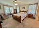 Bedroom with neutral carpet, ceiling fan, furnishings and large window at 175 Hibiscus Way, Leesburg, FL 34748