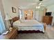 Bedroom with neutral carpet, ceiling fan, wooden furnishings, and ensuite bathroom at 175 Hibiscus Way, Leesburg, FL 34748