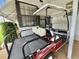 Close-up of a red golf cart parked in a carport with house details visible at 175 Hibiscus Way, Leesburg, FL 34748