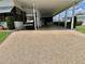 Long carport leading to a house entrance, with golf cart and outdoor seating at 175 Hibiscus Way, Leesburg, FL 34748