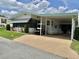 Charming home featuring a covered carport and well-maintained landscaping with vibrant green grass at 175 Hibiscus Way, Leesburg, FL 34748