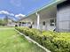 Covered porch showcasing well-maintained hedges and a white exterior at 175 Hibiscus Way, Leesburg, FL 34748