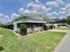 Landscaped front yard featuring lush grass, decorative shrubs, and a paved driveway at 175 Hibiscus Way, Leesburg, FL 34748