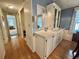 Hallway with hardwood floors connects to the dining room showcasing built-in shelving and storage at 175 Hibiscus Way, Leesburg, FL 34748