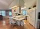 A kitchen featuring an island with seating and ample white cabinetry and appliances at 175 Hibiscus Way, Leesburg, FL 34748