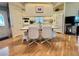 The kitchen features an island with seating, hardwood floors, and white appliances and cabinetry at 175 Hibiscus Way, Leesburg, FL 34748