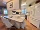 A view of the kitchen with an island with seating, stainless steel appliances, and white cabinets at 175 Hibiscus Way, Leesburg, FL 34748