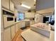 The kitchen features stainless steel appliances, light cabinetry, and hardwood flooring at 175 Hibiscus Way, Leesburg, FL 34748