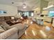 Bright living room boasts open floor plan to dining and kitchen area with gleaming floors throughout at 175 Hibiscus Way, Leesburg, FL 34748