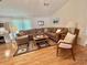 Comfortable living room featuring hardwood floors, a plush sectional, and natural light at 175 Hibiscus Way, Leesburg, FL 34748