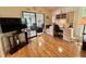 An entertainment center with a TV and built-in shelving, adjacent to a sunroom area with recliners at 175 Hibiscus Way, Leesburg, FL 34748