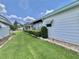 Lush side yard showcasing green grass and trimmed hedges along the property line at 175 Hibiscus Way, Leesburg, FL 34748