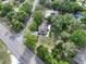 Aerial view of home, revealing tree coverage, road access, and surrounding neighborhood at 18015 Palm St, Umatilla, FL 32784