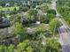 Aerial view of a secluded home surrounded by lush greenery and mature trees with a large grassy lot at 18015 Palm St, Umatilla, FL 32784