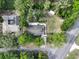Aerial view of a property featuring a home, pool, detached garage, and lush trees at 18015 Palm St, Umatilla, FL 32784