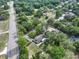 Aerial view of home featuring surrounding landscape, lush trees, and a nearby street at 18015 Palm St, Umatilla, FL 32784