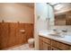Bathroom features wood-paneled walls, tile floors, and a vanity with a sink and a mirror at 18015 Palm St, Umatilla, FL 32784