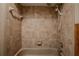 Tiled bathtub and shower feature a hand-held shower head and an ornate flower decal at 18015 Palm St, Umatilla, FL 32784