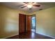 Bedroom features wood floors, ceiling fan, and closet with louvered doors at 18015 Palm St, Umatilla, FL 32784