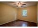Bedroom boasts hardwood floors, a ceiling fan, and a window overlooking the front yard at 18015 Palm St, Umatilla, FL 32784