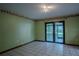 Cozy bedroom with green walls, tile floor, and sliding glass doors leading to the outside patio at 18015 Palm St, Umatilla, FL 32784