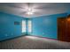 Bedroom with bright blue walls, patterned carpeting, and a ceiling fan at 18015 Palm St, Umatilla, FL 32784