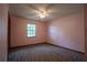 Bedroom with neutral patterned carpet and a window overlooking the front yard at 18015 Palm St, Umatilla, FL 32784