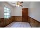 Well-lit dining area featuring paneled walls, a window, and a modern ceiling fan for added comfort at 18015 Palm St, Umatilla, FL 32784