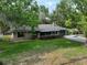 Lovely single-story brick home with a well-manicured lawn and mature trees at 18015 Palm St, Umatilla, FL 32784