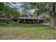 Charming single-story brick home with a well-maintained lawn and mature trees at 18015 Palm St, Umatilla, FL 32784