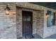 Brick entryway with a security door, decorative lanterns, and a cute doormat at 18015 Palm St, Umatilla, FL 32784