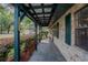 Covered front porch of a brick home with brick facade and dark green wooden supports at 18015 Palm St, Umatilla, FL 32784