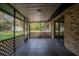 Covered outdoor screened-in porch with brick exterior and patterned tile flooring at 18015 Palm St, Umatilla, FL 32784