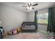 Bedroom with a gray crib, soft carpet, and natural light from the window at 1805 Jefferson Dr, Mount Dora, FL 32757