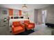 The bedroom features stylish decor, bold orange accents, and a decorative chandelier at 1805 Jefferson Dr, Mount Dora, FL 32757