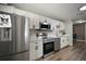 Modern kitchen featuring stainless steel appliances, white cabinetry, and wood-look flooring at 1805 Jefferson Dr, Mount Dora, FL 32757