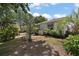 Landscaped backyard featuring tropical plants and a private seating area with a table and chairs at 2003 Cordero Ct, The Villages, FL 32159