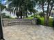 Landscaped backyard featuring a stone bench, lush greenery, and views of neighboring homes at 2003 Cordero Ct, The Villages, FL 32159
