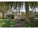 Well-maintained backyard featuring lush landscaping, a paver patio, and a cozy sunroom at 2003 Cordero Ct, The Villages, FL 32159