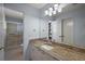 Bathroom featuring a granite vanity, large mirror and walk-in shower with glass doors at 2003 Cordero Ct, The Villages, FL 32159
