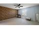 Spacious bedroom with a decorative brick wall, neutral tile floors, ceiling fan and a bright window at 2003 Cordero Ct, The Villages, FL 32159