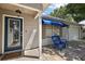 Charming front entrance with blue door, paver patio, and two blue chairs for relaxing outdoors at 2003 Cordero Ct, The Villages, FL 32159