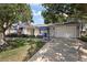 Charming single-story home with an attached garage, blue awnings, and well-maintained landscaping at 2003 Cordero Ct, The Villages, FL 32159