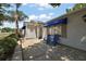 Welcoming front patio with blue Adirondack chairs and awnings provide a relaxing outdoor space at 2003 Cordero Ct, The Villages, FL 32159