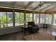 Bright sunroom featuring wood floors, neutral walls, comfortable seating, and a ceiling fan at 2003 Cordero Ct, The Villages, FL 32159